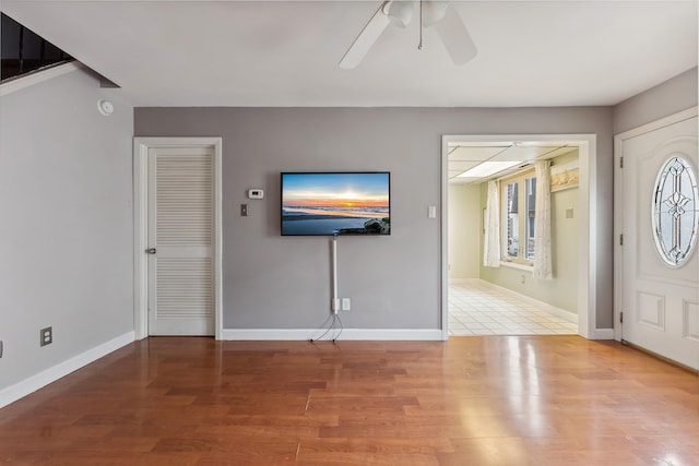 foyer entrance featuring wood finished floors, baseboards, and ceiling fan