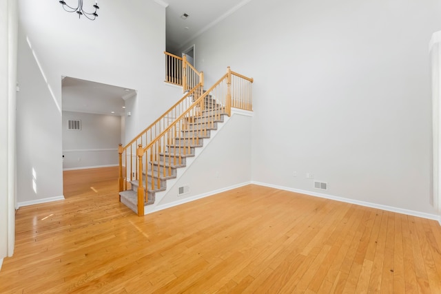 201 Saint Andrews Dr Unit 201, Swainton, NJ 08210 - staircase with baseboards, hardwood / wood-style flooring, crown molding, and a towering ceiling