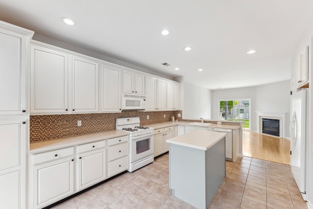 201 Saint Andrews Dr Unit 201, Swainton, NJ 08210 - kitchen with white appliances, backsplash, a peninsula, a center island, and light countertops