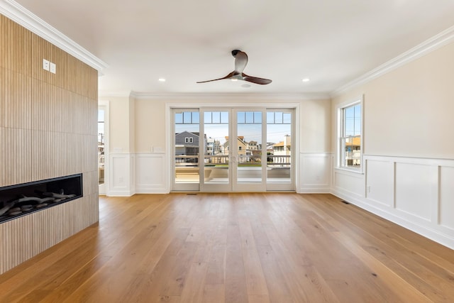 427 E 5th Ave, North Wildwood, NJ 08260 - unfurnished living room with a decorative wall, ornamental molding, a ceiling fan, light wood-style flooring, and a wainscoted wall