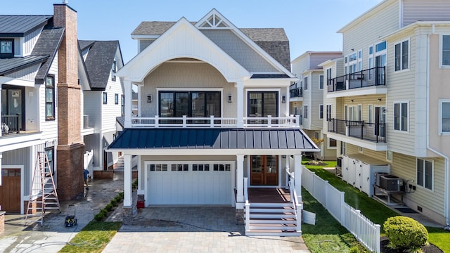 427 E 5th Ave, North Wildwood, NJ 08260 - view of front of property with an attached garage, decorative driveway, a shingled roof, and a balcony