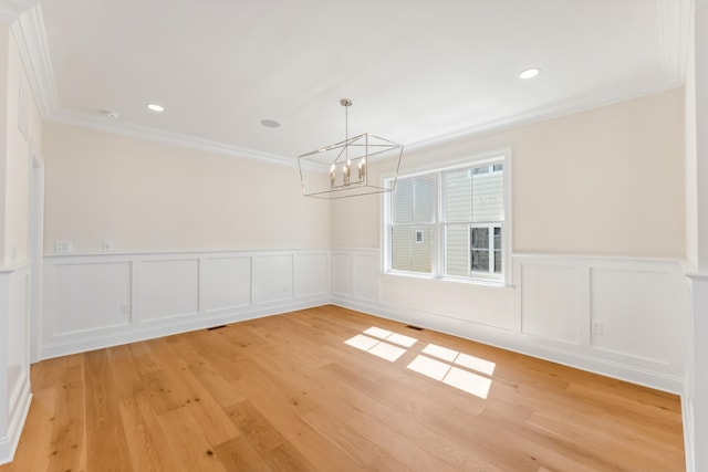 427 E 5th Ave, North Wildwood, NJ 08260 - unfurnished dining area with crown molding, a chandelier, light wood-type flooring, a decorative wall, and wainscoting