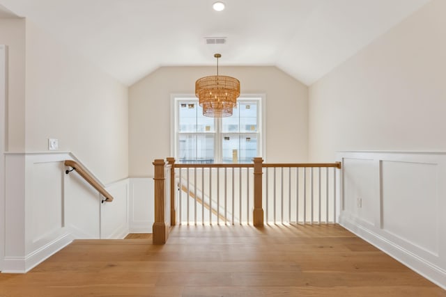 427 E 5th Ave, North Wildwood, NJ 08260 - hallway featuring an upstairs landing, a chandelier, light wood-style floors, a decorative wall, and a wainscoted wall