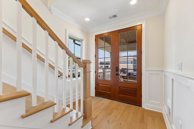 427 E 5th Ave, North Wildwood, NJ 08260 - foyer entrance with stairway, french doors, light wood-type flooring, ornamental molding, and a wainscoted wall