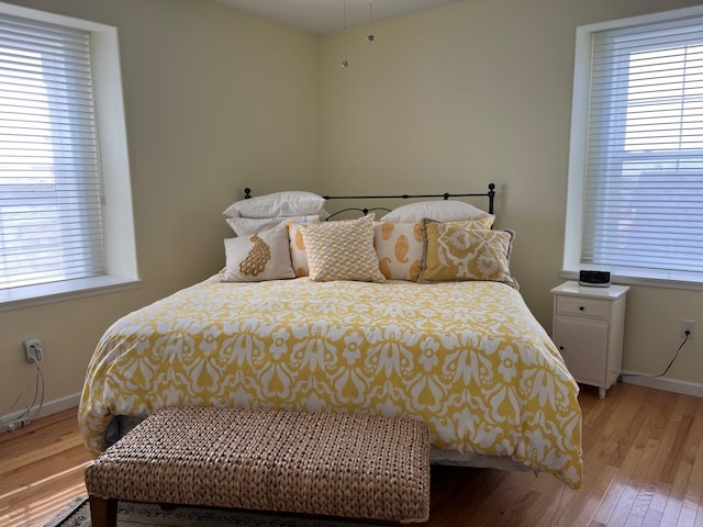 bedroom with light hardwood / wood-style floors and multiple windows