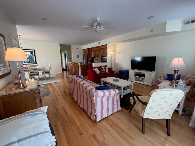 living room with ceiling fan and light hardwood / wood-style flooring