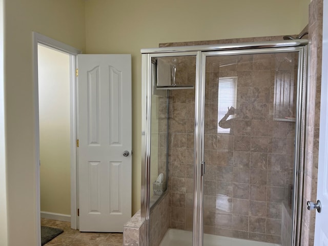 bathroom with an enclosed shower and tile patterned floors