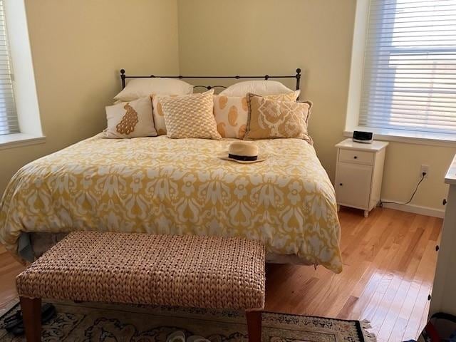 bedroom with light hardwood / wood-style flooring and multiple windows