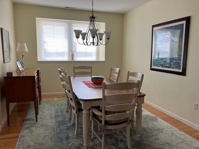 dining area with a notable chandelier and wood-type flooring