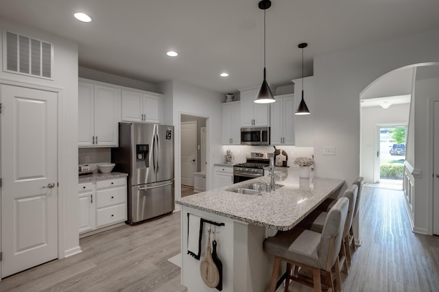 106 Bay Breeze Blvd Unit 106, Cape May Court House, NJ 08210 - kitchen featuring appliances with stainless steel finishes, arched walkways, light wood-style floors, white cabinets, and recessed lighting