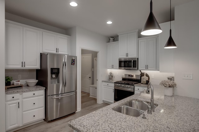 106 Bay Breeze Blvd Unit 106, Cape May Court House, NJ 08210 - kitchen with stainless steel appliances, a sink, white cabinets, light wood finished floors, and decorative light fixtures