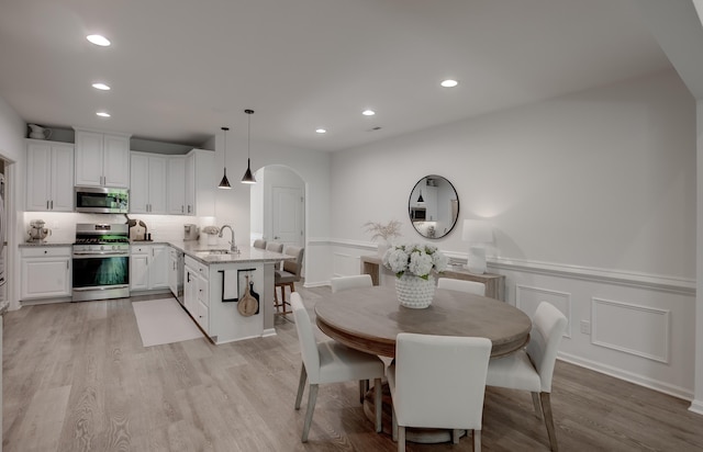 106 Bay Breeze Blvd Unit 106, Cape May Court House, NJ 08210 - dining area with arched walkways, recessed lighting, light wood-style floors, a wainscoted wall, and a decorative wall