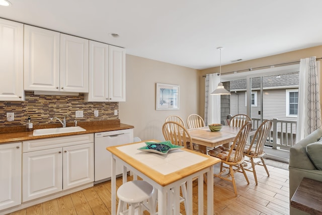 kitchen with backsplash, sink, decorative light fixtures, dishwasher, and white cabinetry