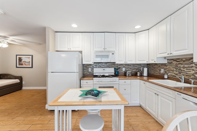 kitchen featuring backsplash, white appliances, ceiling fan, sink, and white cabinetry