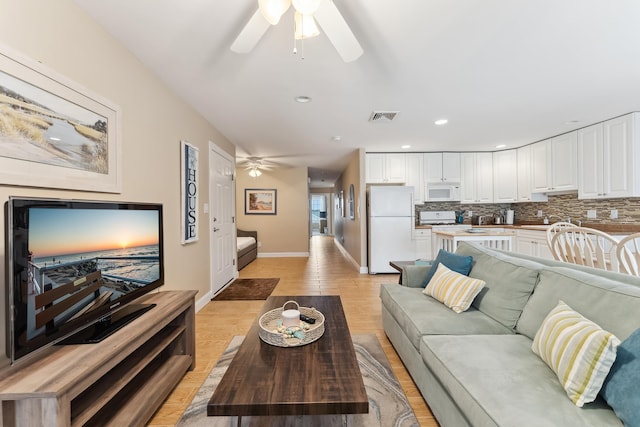 living room with ceiling fan and light hardwood / wood-style floors