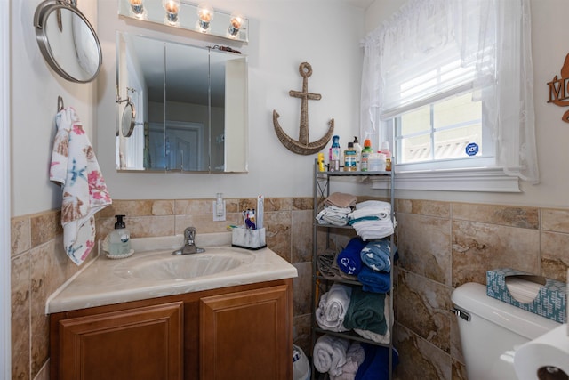 bathroom with vanity, tile walls, and toilet