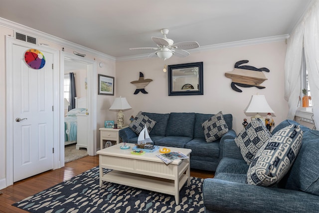 living room with hardwood / wood-style flooring, ceiling fan, and crown molding