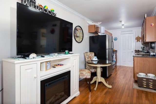 kitchen featuring stainless steel refrigerator, crown molding, and wood-type flooring