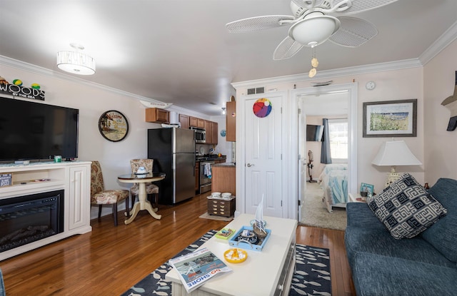 living room featuring ceiling fan, ornamental molding, and dark wood-type flooring