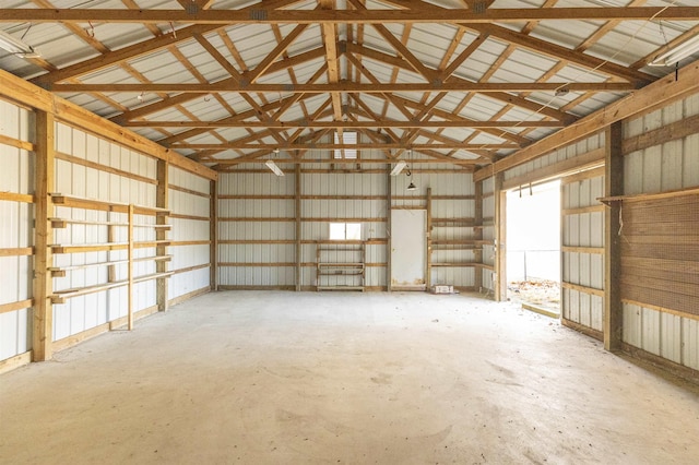 interior space featuring high vaulted ceiling and concrete floors