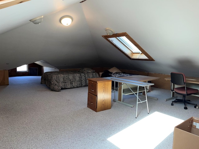 interior space featuring carpet and vaulted ceiling with skylight