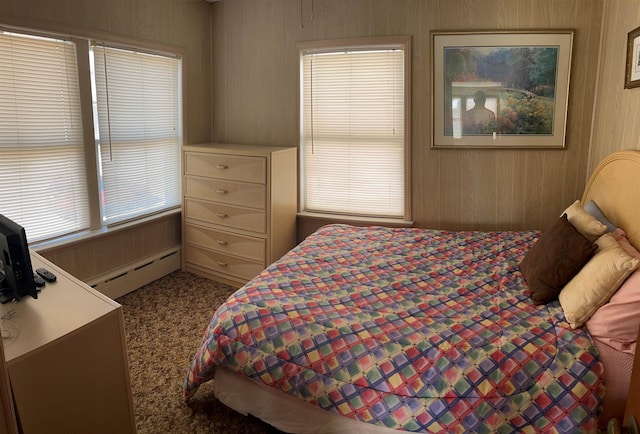 bedroom with a baseboard radiator and wooden walls