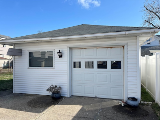 garage with driveway and fence