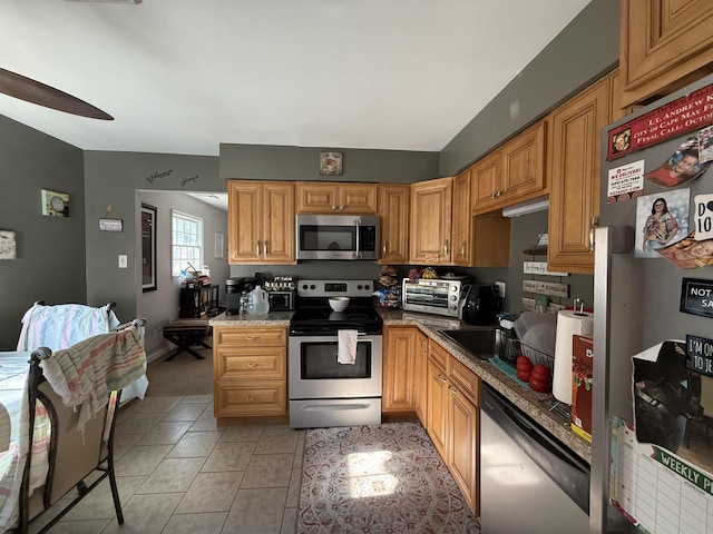 kitchen featuring ceiling fan, light tile patterned floors, and stainless steel appliances