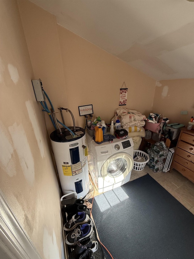 additional living space with tile patterned floors, electric water heater, and washer / clothes dryer