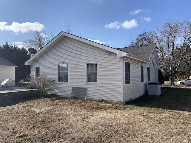 view of side of home with a patio area, a yard, and central AC