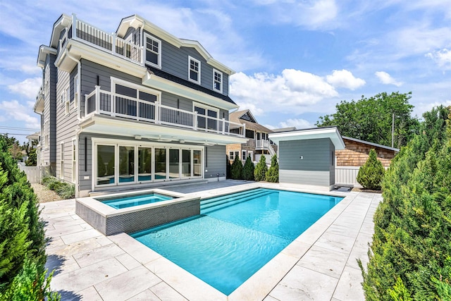 151 37th St, Avalon, NJ 08202 - back of property with a balcony, an in-ground hot tub, a patio area, and an outdoor pool
