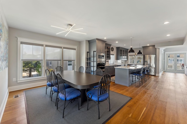 dining space featuring baseboards, healthy amount of natural light, light wood-style floors, a ceiling fan, and recessed lighting