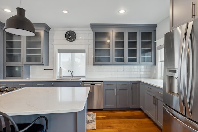 kitchen with appliances with stainless steel finishes, gray cabinets, a sink, decorative backsplash, and recessed lighting