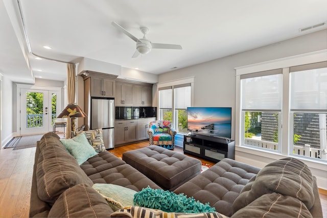 living area with light wood-type flooring, a ceiling fan, and recessed lighting