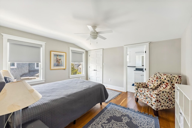 bedroom featuring wood finished floors, vaulted ceiling, baseboards, a closet, and a ceiling fan