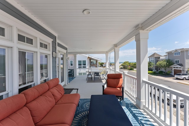 view of patio featuring a porch, an outdoor living space, and a residential view