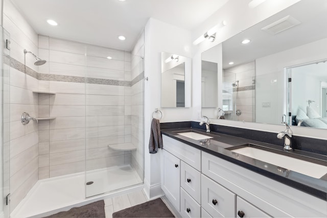 ensuite bathroom with a stall shower, double vanity, and recessed lighting