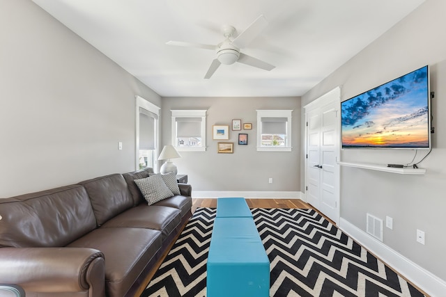 living room featuring ceiling fan and baseboards