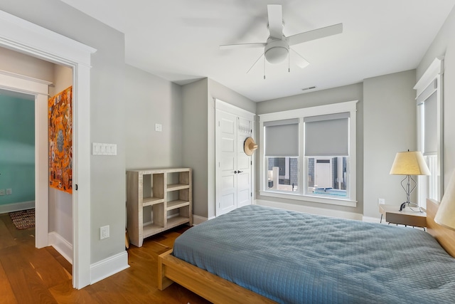 bedroom featuring wood finished floors, baseboards, and ceiling fan