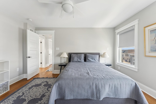 bedroom featuring wood finished floors, baseboards, and a ceiling fan