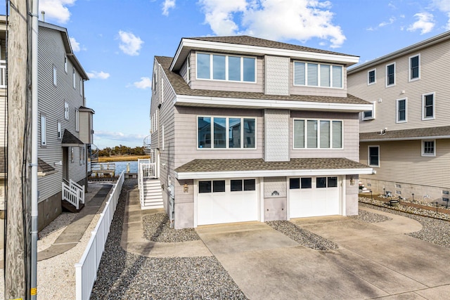 view of front of home featuring a garage, concrete driveway, and roof with shingles