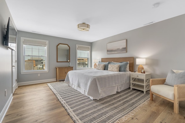 bedroom with multiple windows and light hardwood / wood-style floors