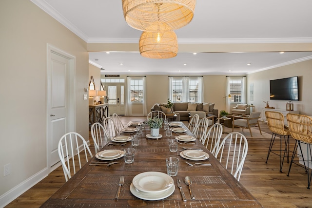 dining room with hardwood / wood-style flooring and crown molding