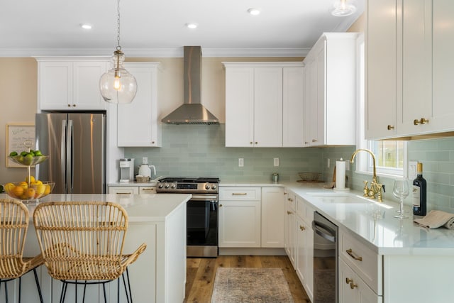 kitchen featuring decorative backsplash, sink, stainless steel appliances, and wall chimney range hood