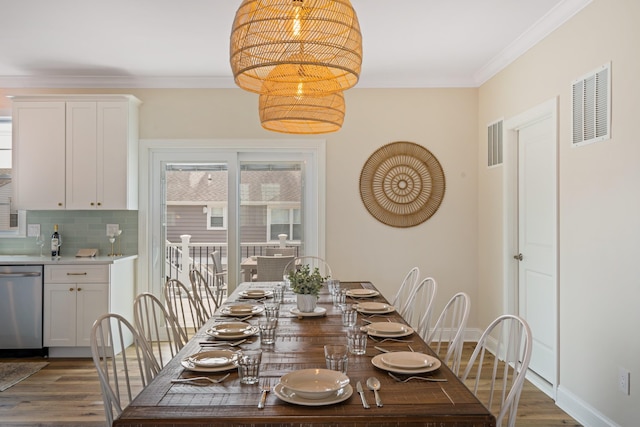 dining room with dark hardwood / wood-style flooring and crown molding