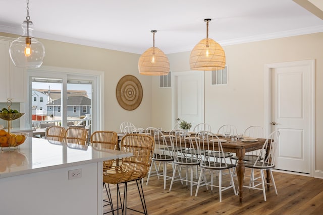 dining area featuring crown molding and hardwood / wood-style flooring