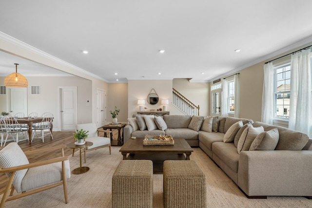 living room with light wood-type flooring and crown molding