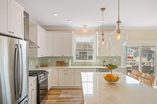 kitchen with white cabinetry, sink, light stone countertops, decorative light fixtures, and appliances with stainless steel finishes