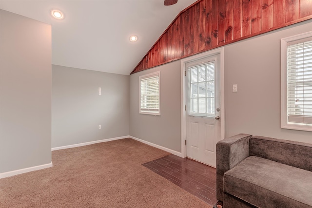 foyer featuring vaulted ceiling, plenty of natural light, and carpet