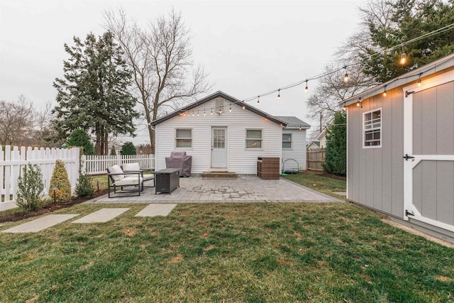 rear view of house featuring a storage shed, a patio area, and a lawn